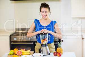 Beautiful young woman preparing juice