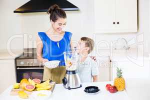 Mother assisting son to prepare juice