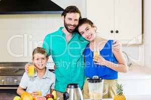 Family holding juice in kitchen