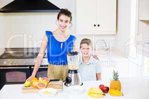 Mother and son standing at table in kitchen