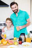 Father and son holding glass of a juice
