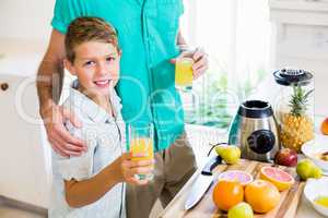 Father and son holding glass of a juice