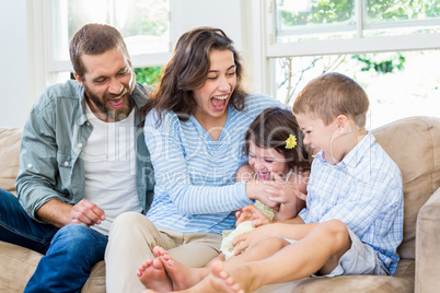 Parents and kids sitting on sofa and having fun