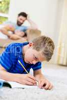 Boy doing homework in living room