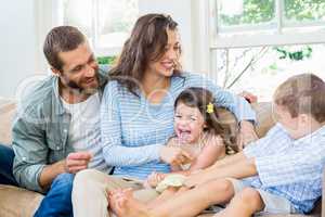 Parents and kids sitting on sofa and having fun