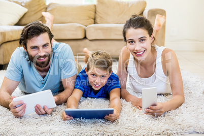 Portrait of parents and son using a laptop, tablet and phone