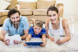 Portrait of parents and son using a laptop, tablet and phone