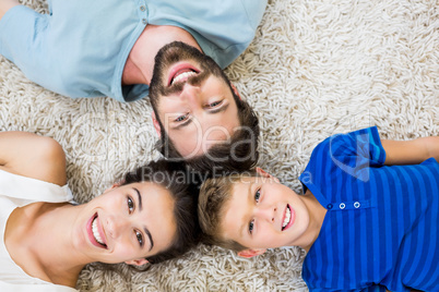 Portrait of parents and son lying on rug