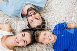 Portrait of parents and son lying on rug