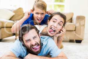 Portrait of parents and son lying on rug and having fun