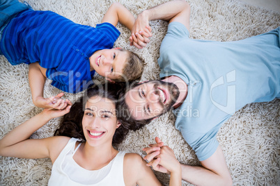 Portrait of parents and son lying on rug