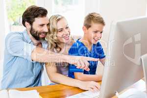 Parents and son using computer in living room