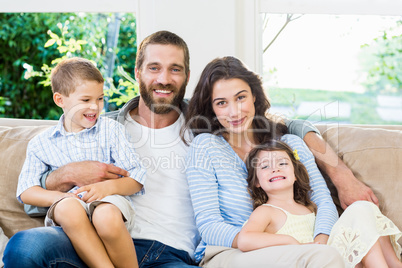 Parents and kids sitting on sofa in living room