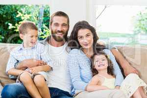 Parents and kids sitting on sofa in living room