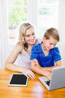 Happy mother and son using laptop