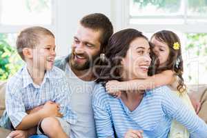 Parents and kids sitting on sofa and having fun