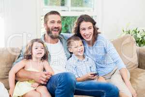 Family and son sitting on sofa and watching television