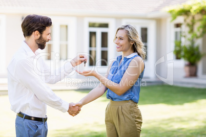 Real estate agent giving keys to woman