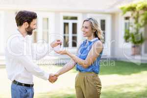 Real estate agent giving keys to woman