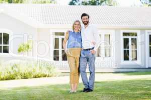 Portrait of happy couple standing with arm around