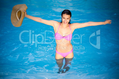 Beautiful woman in bikini standing in swimming pool