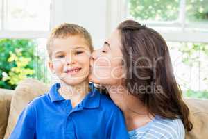 Mother kissing her son in living room