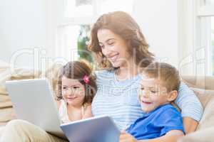 Mother sitting with her kids on sofa