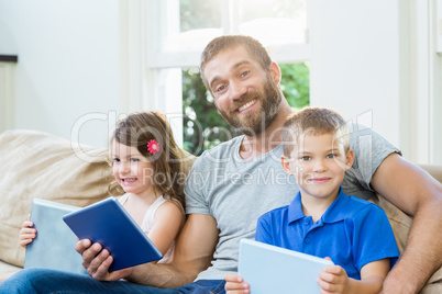Father sitting with his kids on sofa