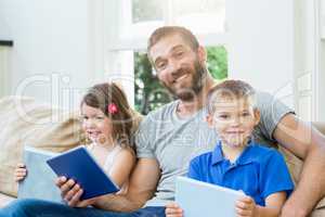 Father sitting with his kids on sofa