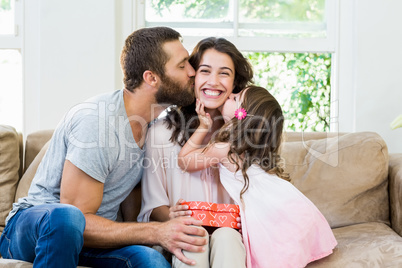 Mother receiving a gift from her husband and daughter