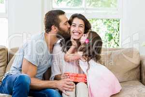 Mother receiving a gift from her husband and daughter