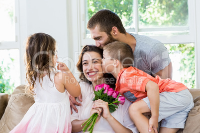 Mother receiving bunch of flowers from her family