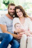 Happy parents with their baby in living room