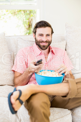 Man sitting on sofa watching television