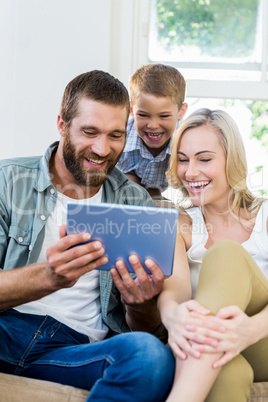 Family using digital tablet in living room Family using digital tablet in living room