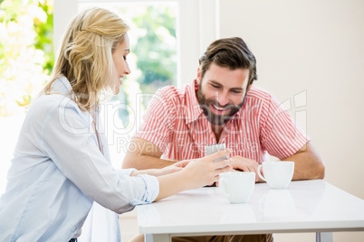 Woman showing her mobile phone to man