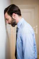 Depressed man leaning his head on wall