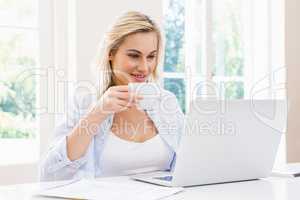 Woman using laptop while having a coffee