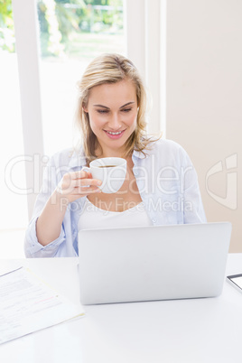 Woman using laptop while having a coffee