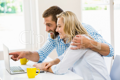 Happy young couple using laptop