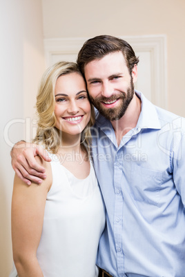 Happy couple standing with arm around