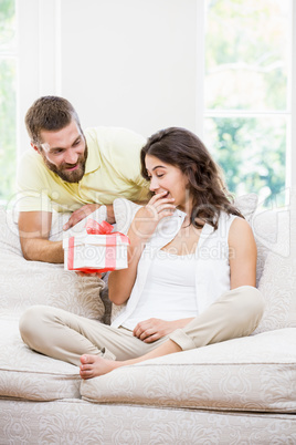 Man giving a surprise gift to her woman