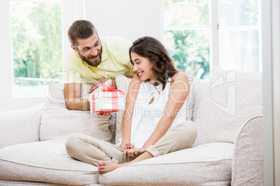 Man giving a surprise gift to her woman