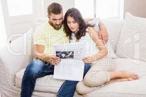 Couple reading newspaper in living room