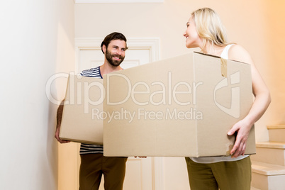 Young couple carrying card board boxes