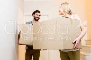 Young couple carrying card board boxes