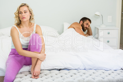 Upset couple ignoring each other after fight on bed