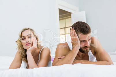 Upset couple ignoring each other after fight on bed