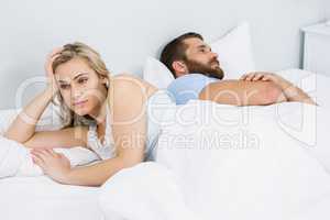 Couple upset after having a fight on bed