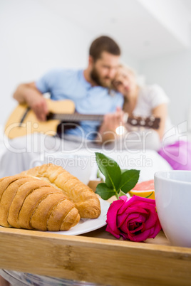 Croissant and a rose on tray